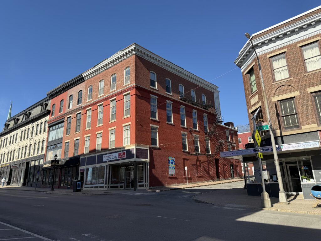 Historic red brick building at 81 Main Street in downtown Bangor, Maine, with ground-floor storefronts
