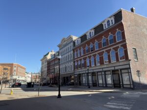 Historic commercial brick buildings on West Market Square in downtown Bangor, Maine, on a clear sunny day