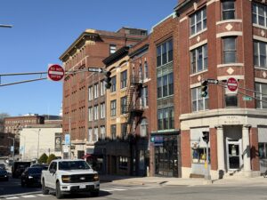 Historic brick buildings at the corner of State and Harlow Streets in downtown Bangor, Maine, with the Pearl Building and Orono Brewing Company