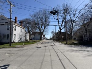 Quiet residential street in Bangor, Maine with bare trees and older New England homes in early spring