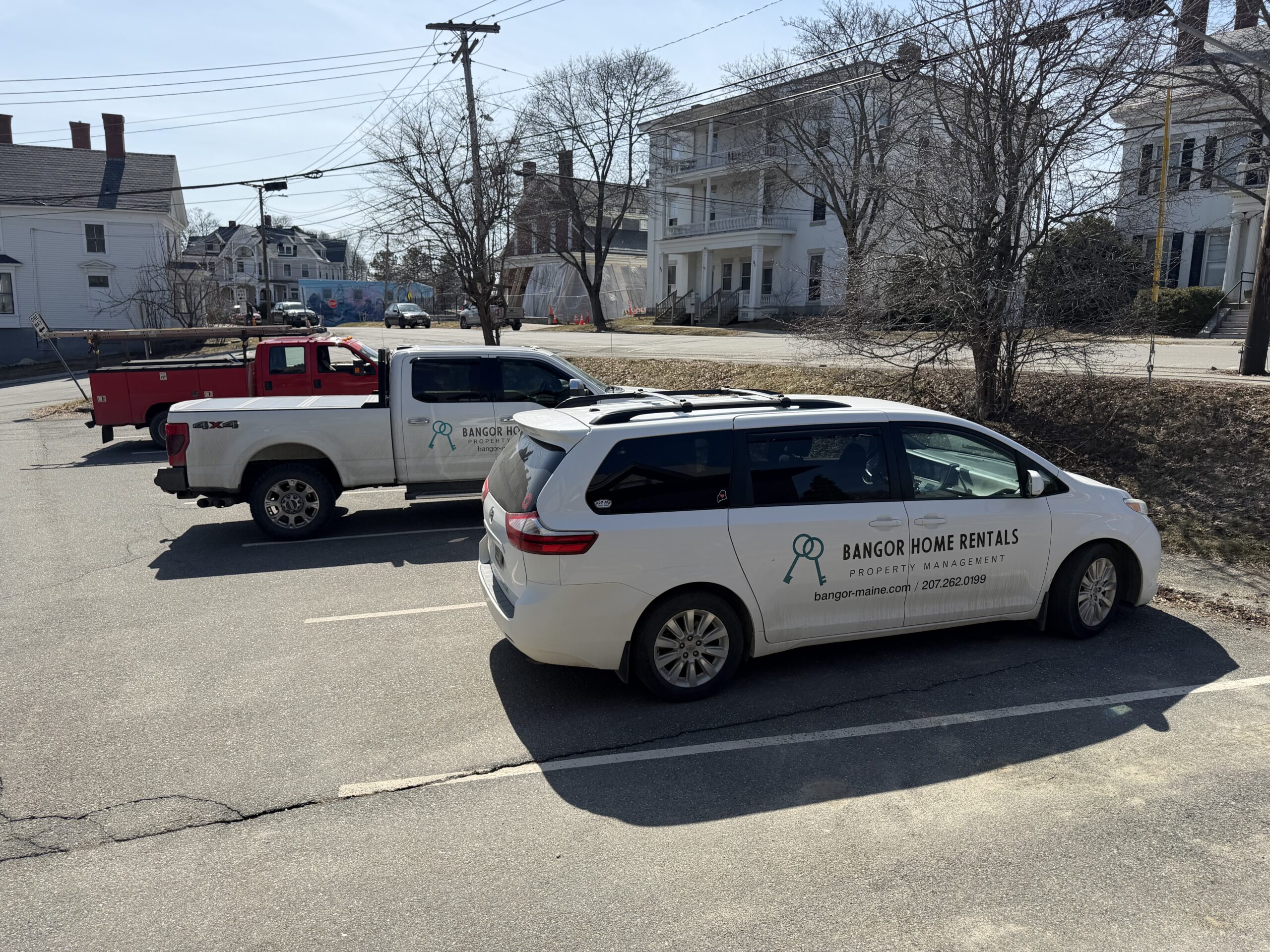 Bangor Home Rentals property management vehicles parked in Bangor Maine residential neighborhood
